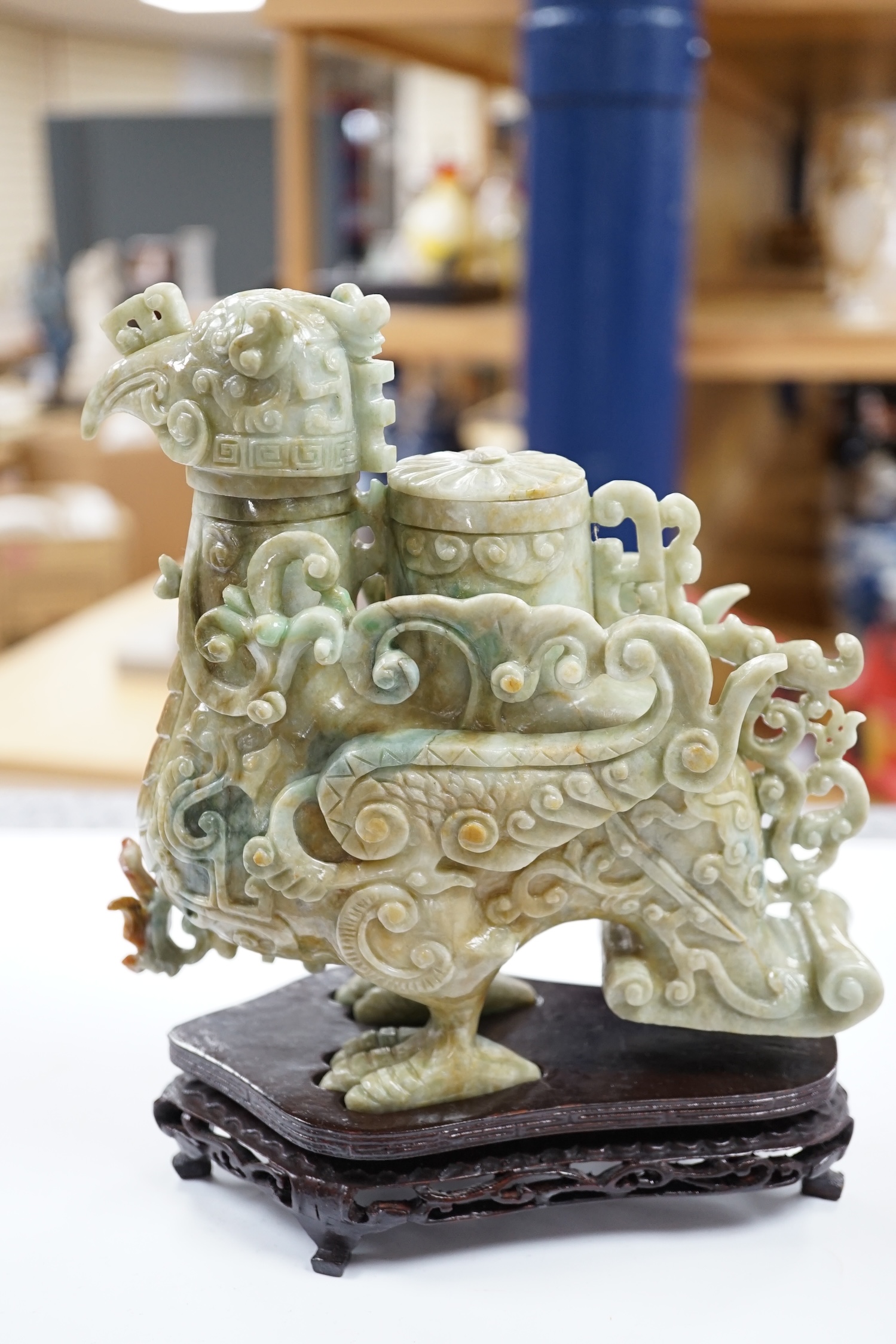 A large Chinese archaistic jadeite ‘phoenix’ vessel and cover, wood stand, 22cm high. Condition - fair